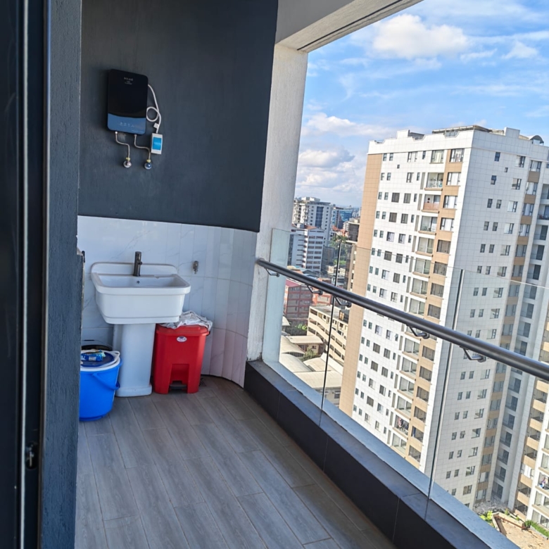 Wide-angle view of a private balcony at Oak Classic Residency Kilimani featuring glass railings and tiled flooring.