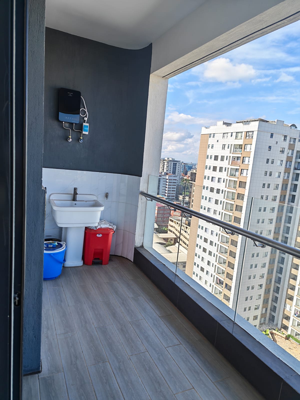 Wide-angle view of a private balcony at Oak Classic Residency Kilimani featuring glass railings and tiled flooring.