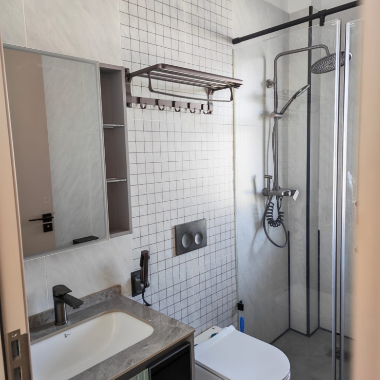 Contemporary bathroom with a glass shower cubicle and modern vanity mirror.
