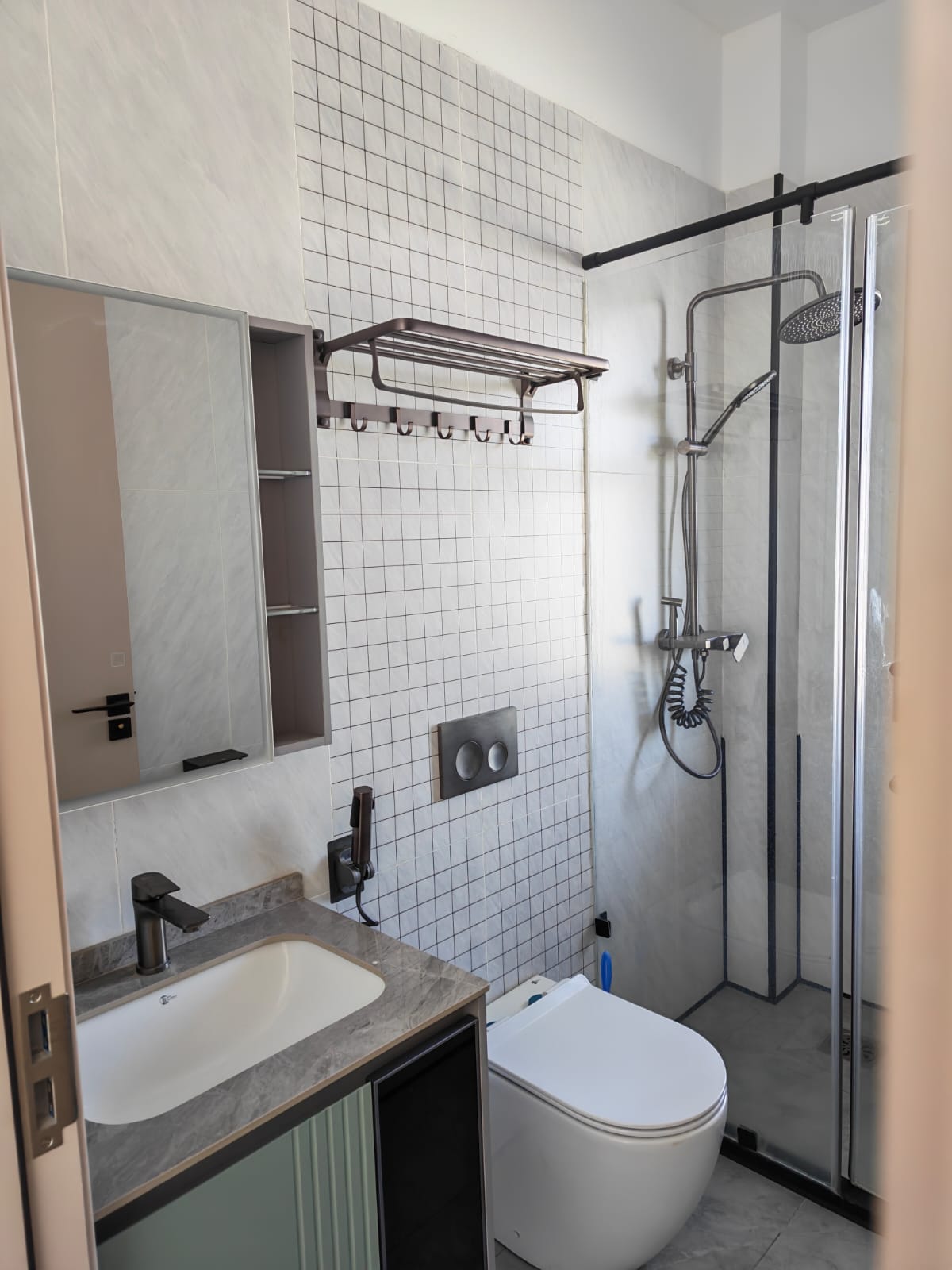 Contemporary bathroom with a glass shower cubicle and modern vanity mirror.