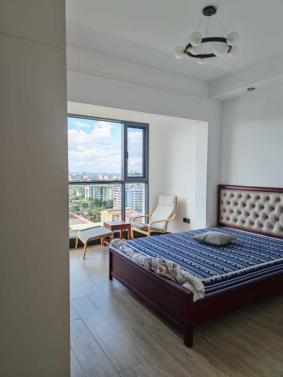 Spacious master bedroom with large windows and polished wood-effect flooring in Kilimani.