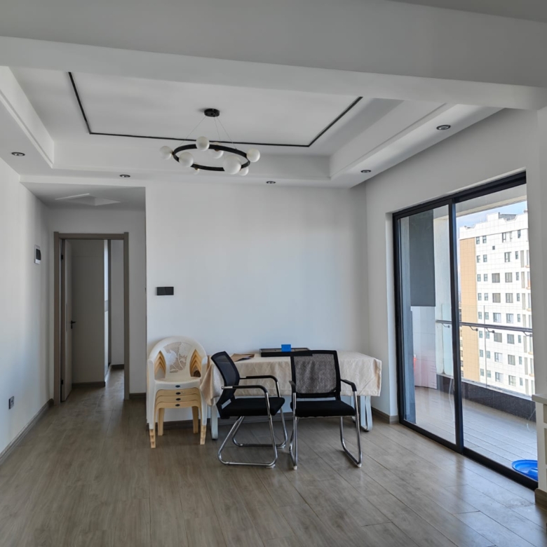 Bright and airy unfurnished lounge at Oak Classic Residency featuring large floor-to-ceiling windows and direct access to a spacious balcony with city views.
