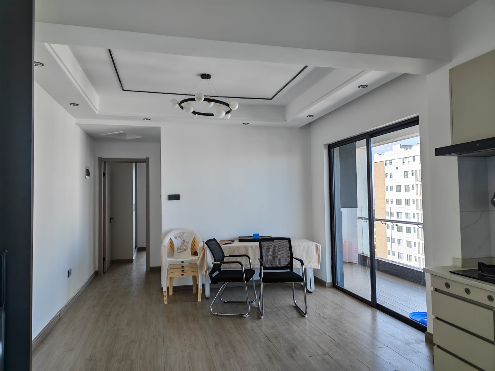 Bright and airy unfurnished lounge at Oak Classic Residency featuring large floor-to-ceiling windows and direct access to a spacious balcony with city views.