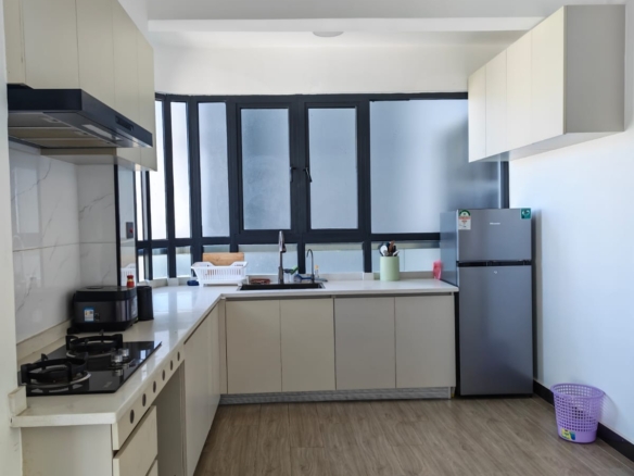 Modern unfurnished kitchen with granite countertops and built-in cabinetry in a 1-bedroom Kilimani flat.