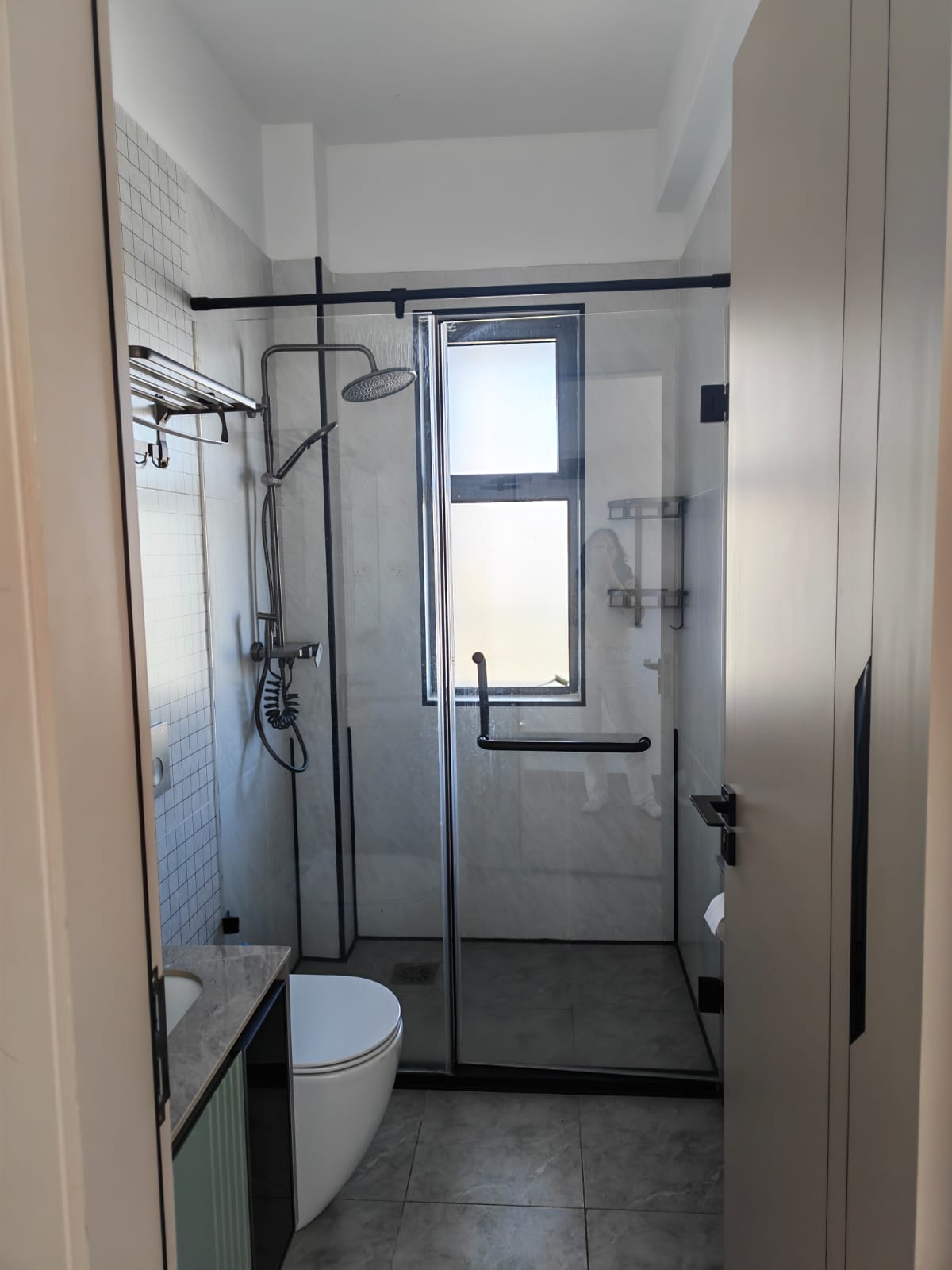 Clean, tiled bathroom interior featuring high-end sanitary ware and chrome fixtures.