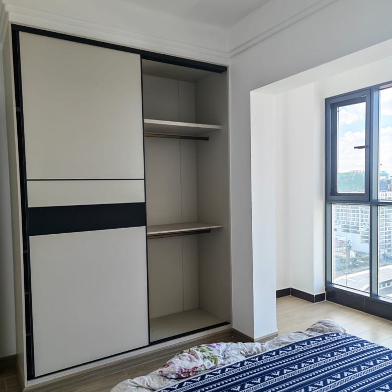 Custom-built floor-to-ceiling wooden storage cabinets in a 56sqm Kilimani apartment.