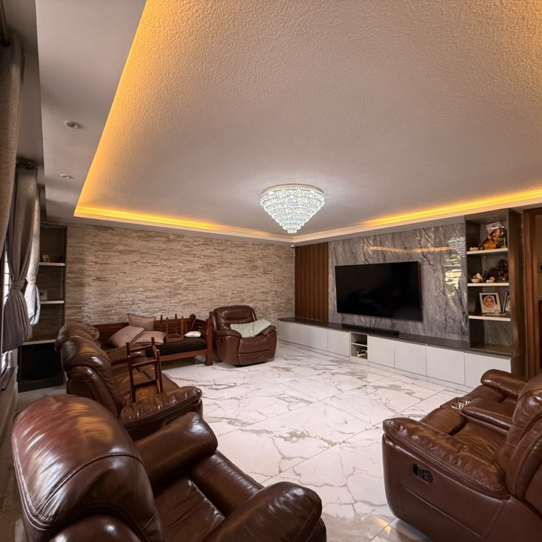 Family lounge with fitted entertainment wall at Convent Oaks Lavington