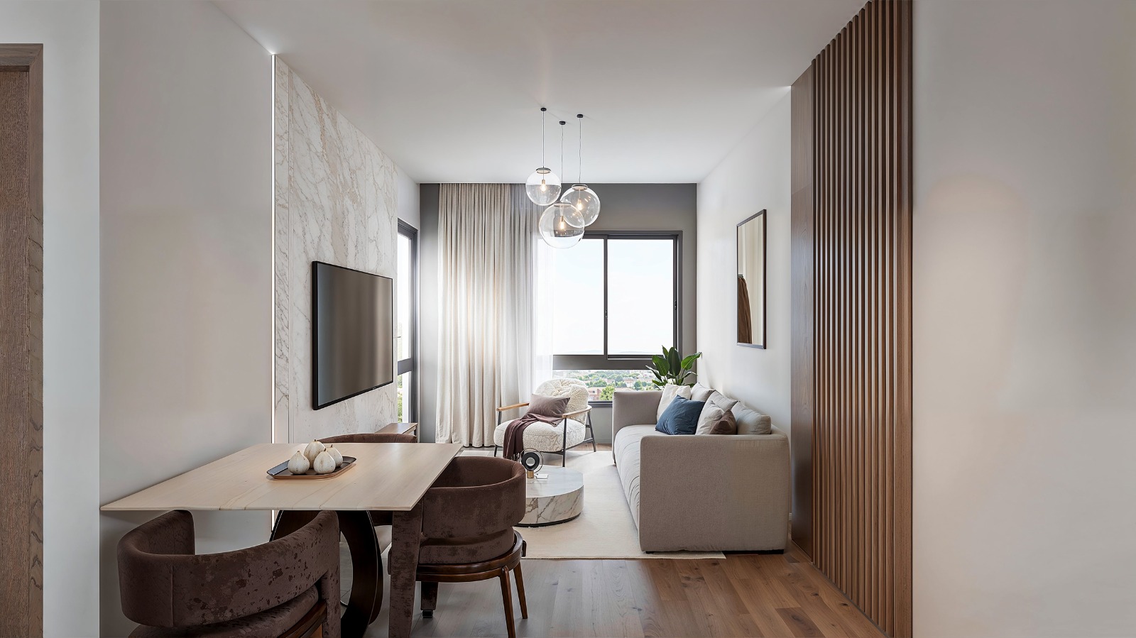 Baystar residence contemporary living room with comfortable sofa, dining table, modern pendant lights and large windows.