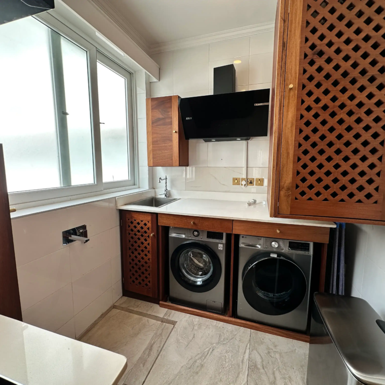 Utility room with washing machine, dryer and storage cabinets