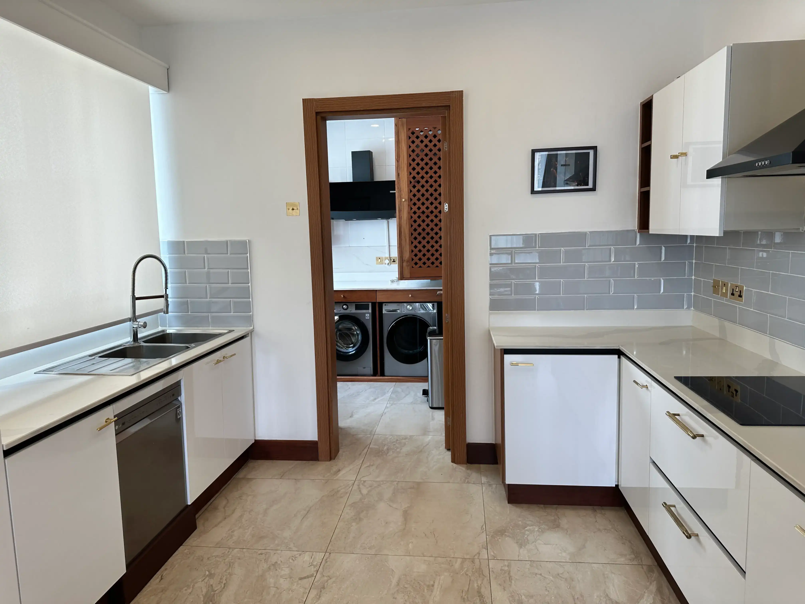 White fitted kitchen with double sink and utility-room access