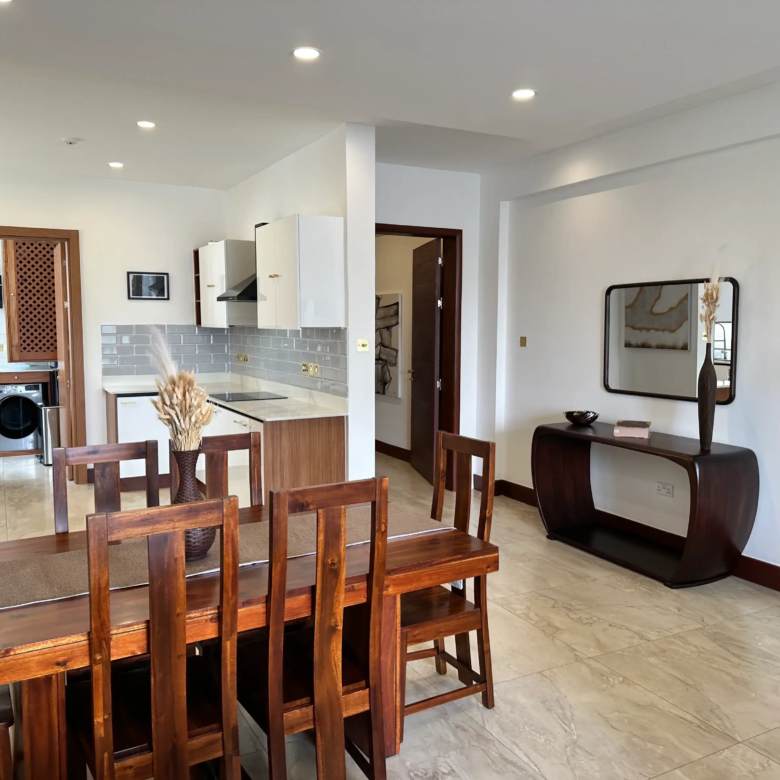 Six-seat wooden dining table beside a fitted kitchen
