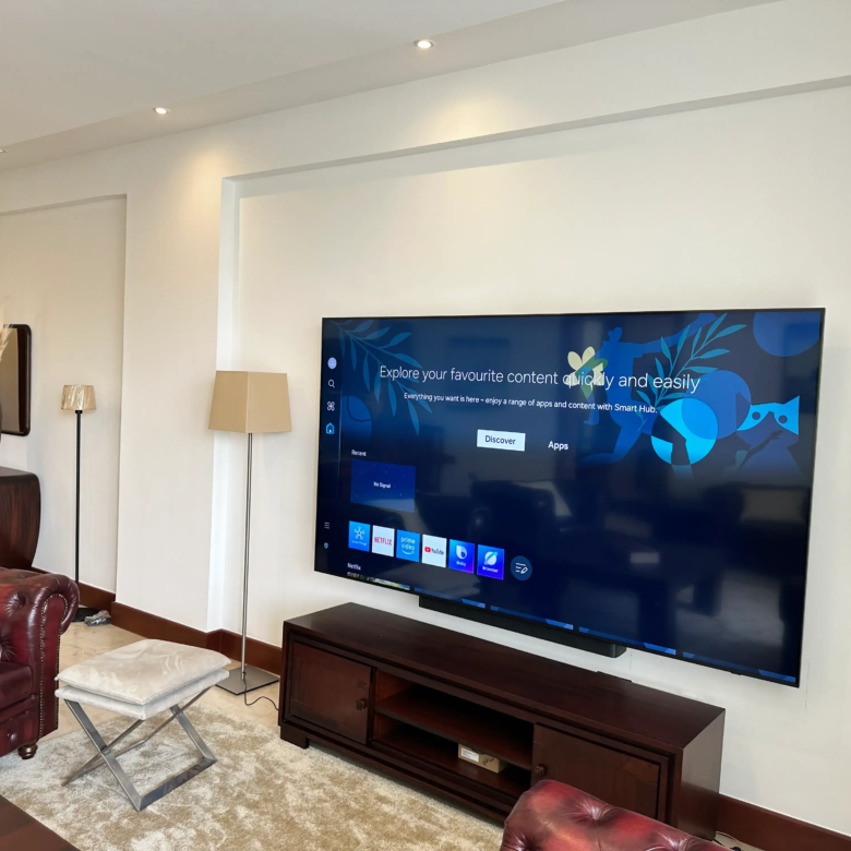 Large wall-mounted television in a furnished living room