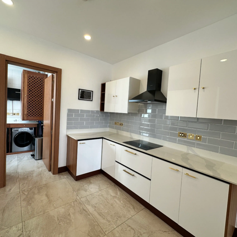 Modern white kitchen cabinets with stone worktop and electric hob