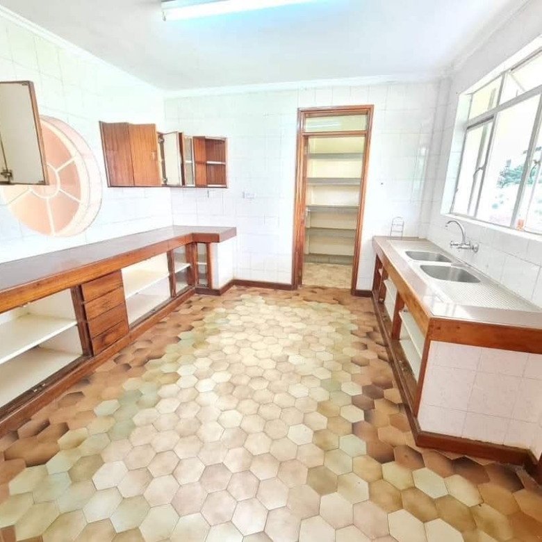 Spacious fitted kitchen with wooden cabinets, pantry storage and double sink in Riverside Drive apartment