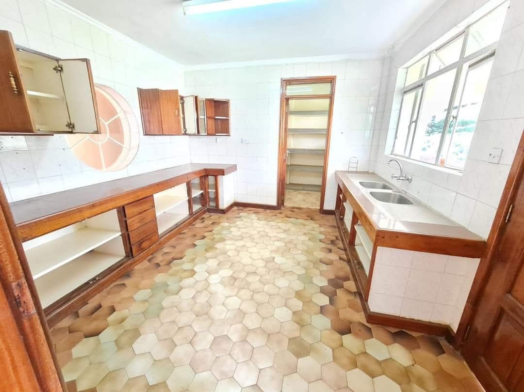 Spacious fitted kitchen with wooden cabinets, pantry storage and double sink in Riverside Drive apartment