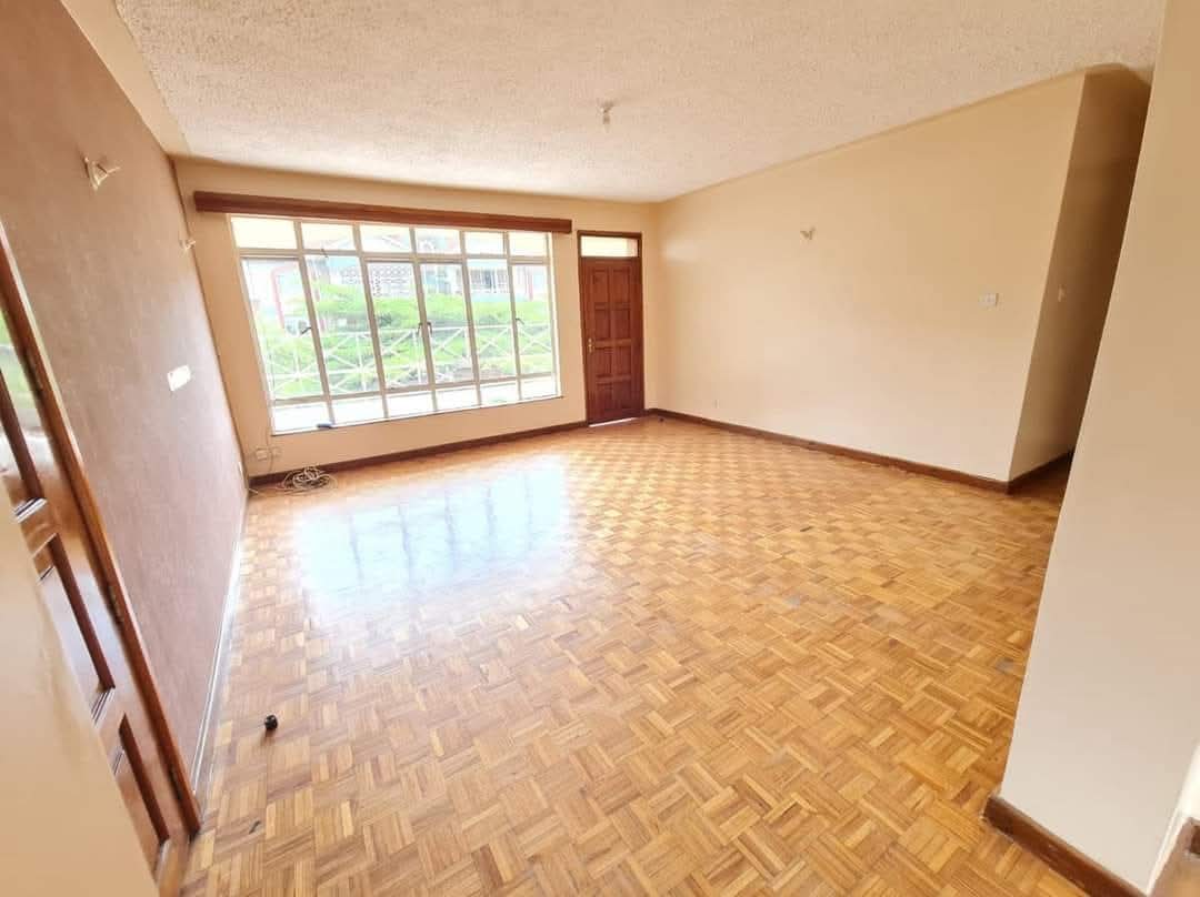 Bright family room with wood-effect flooring and multiple windows in a Riverside Drive apartment