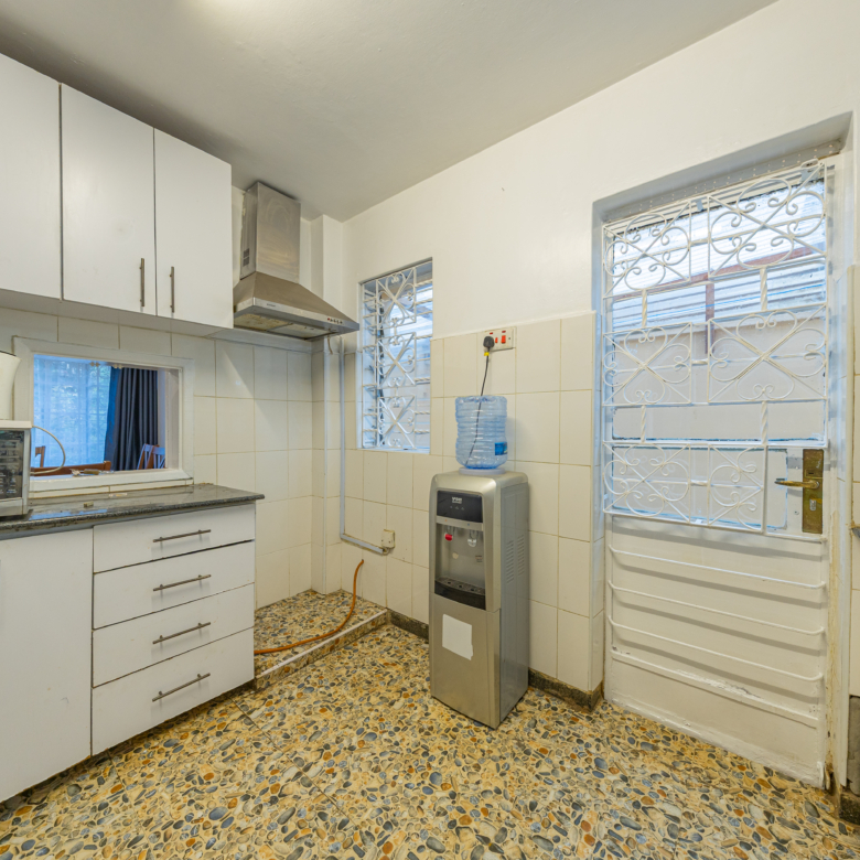 Guest bathroom featuring a toilet, wash basin, tiled walls and tiled flooring within the Oloitoktok Court townhouse.