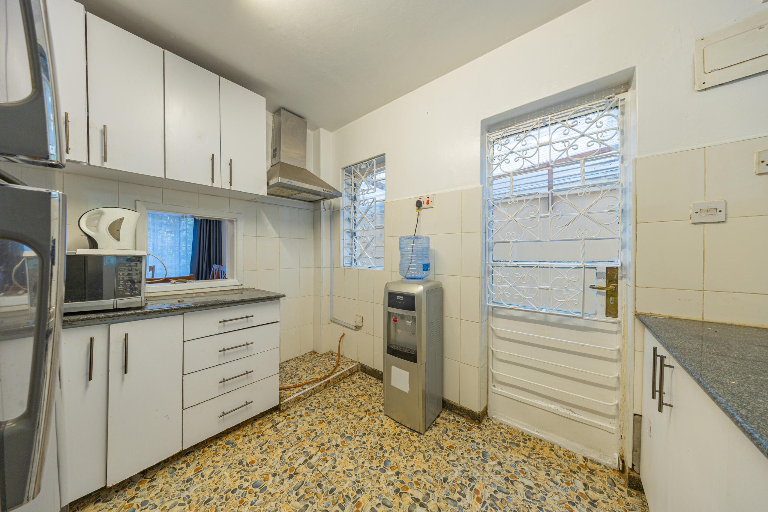 Guest bathroom featuring a toilet, wash basin, tiled walls and tiled flooring within the Oloitoktok Court townhouse.