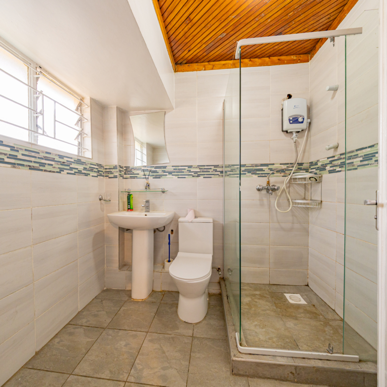 Tiled bathroom with glass shower enclosure at Oloitoktok Court Kileleshwa