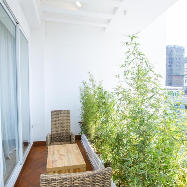 Furnished private balcony with seating and greenery in a serviced Parklands apartment