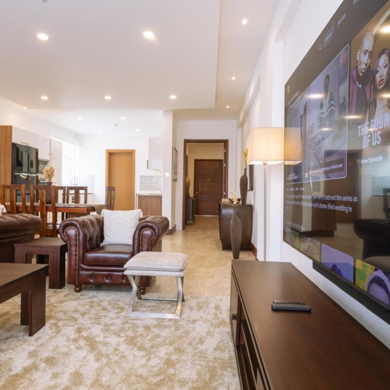 Spacious living room with large television in a serviced 2 bedroom Parklands apartment