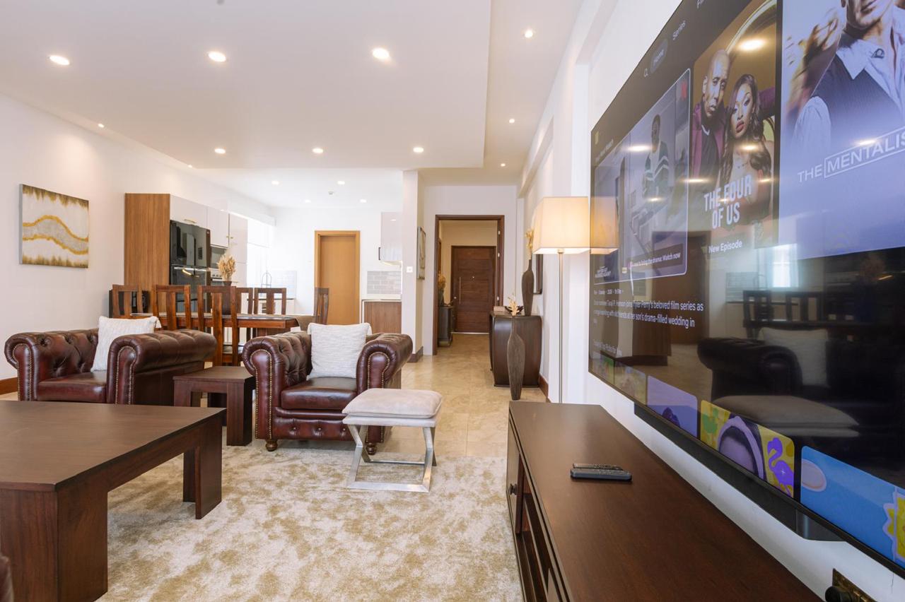 Spacious living room with large television in a serviced 2 bedroom Parklands apartment