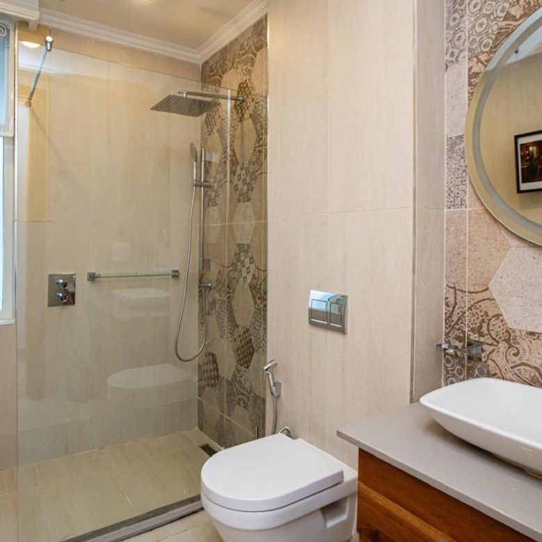Modern bathroom with walk-in shower, vanity basin and patterned tiles in Parklands apartment