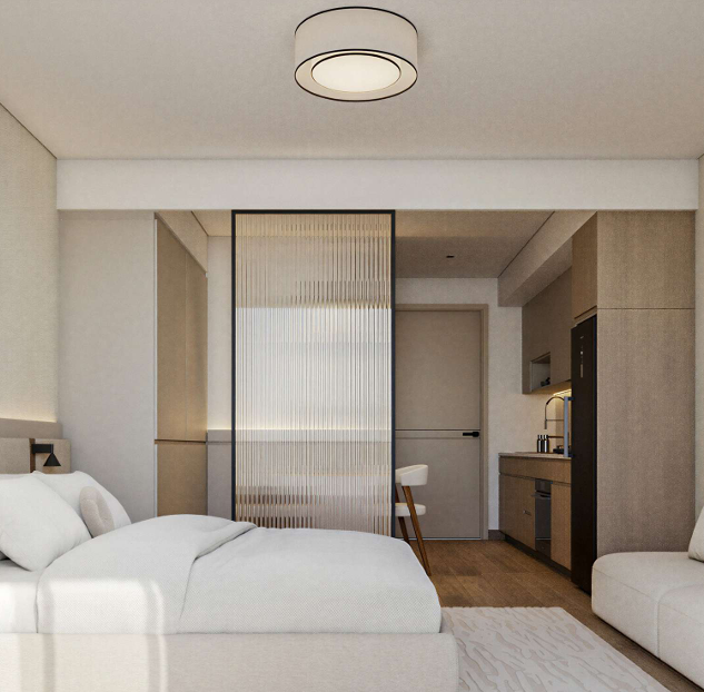 AERA Westlands studio apartment interior featuring a modern bedroom, transparent partition, fitted kitchenette and contemporary furnishings.