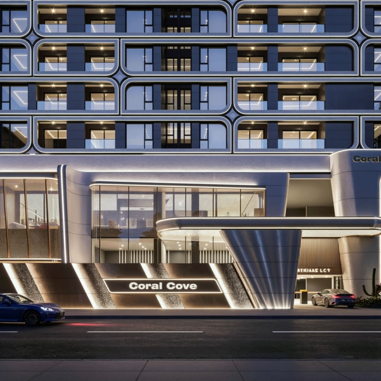 Coral Cove Residence luxury apartment entrance featuring modern architectural design, illuminated facade, glass windows and a stylish driveway at night.