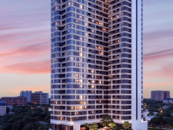 Coral Cove Residence high-rise luxury apartment tower featuring a modern curved glass facade, illuminated balconies and landscaped gardens at sunset.