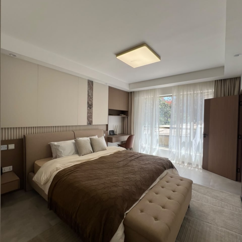 Express View Residency luxury bedroom design featuring a large upholstered bed, fitted wardrobes, modern bedside tables, pendant lights, and a floor-to-ceiling window overlooking the city.