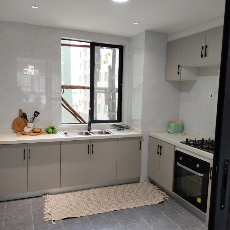 Himalaya Heights modern fitted kitchen with built-in oven, gas hob, double sink, spacious cabinets and large window in Kilimani.