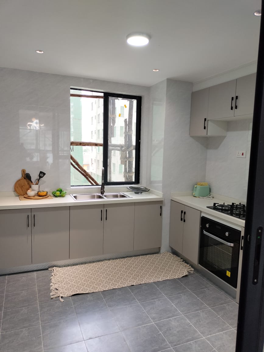 Himalaya Heights modern fitted kitchen with built-in oven, gas hob, double sink, spacious cabinets and large window in Kilimani.