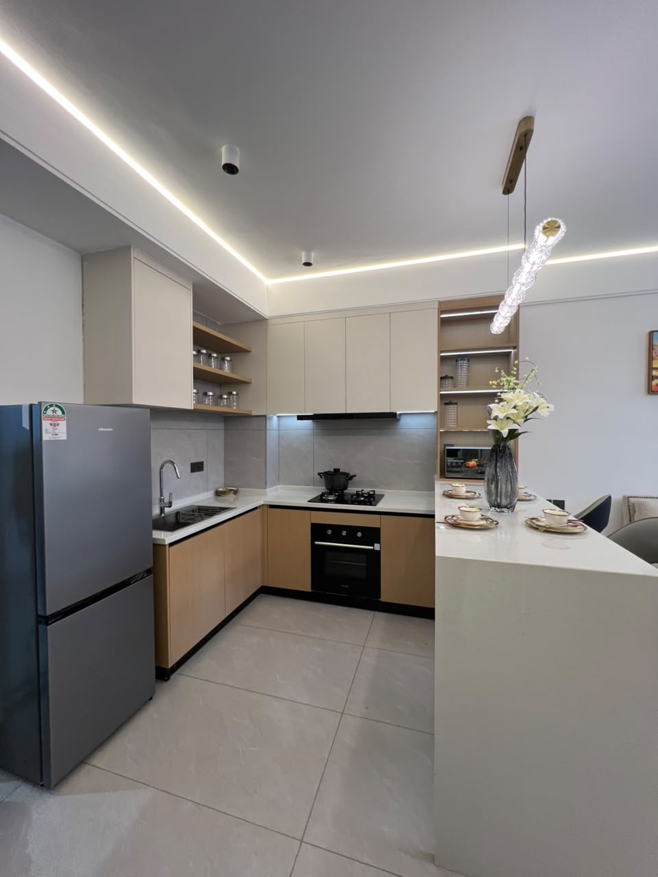 Longines Bay fitted kitchen with breakfast island, integrated oven, modern cabinetry and stainless steel refrigerator.