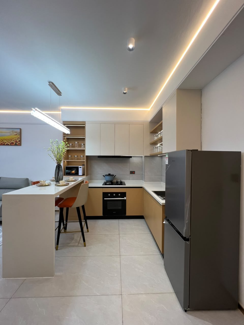 Longines Bay apartment kitchen with fitted cabinets, breakfast counter, built-in oven and modern appliances.