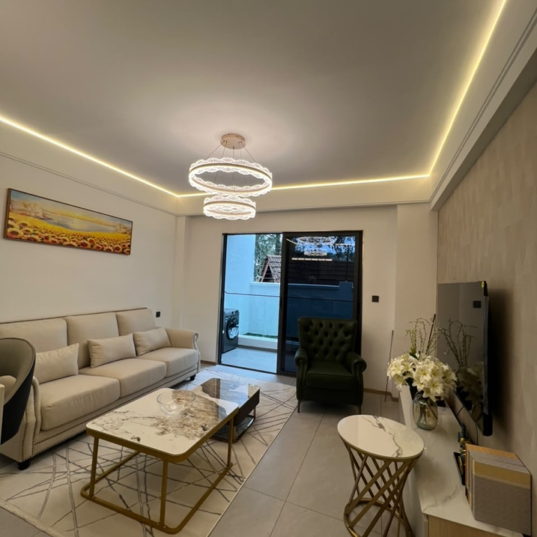 Longines Bay modern living room with upholstered sofa, television unit, decorative coffee tables and balcony access.