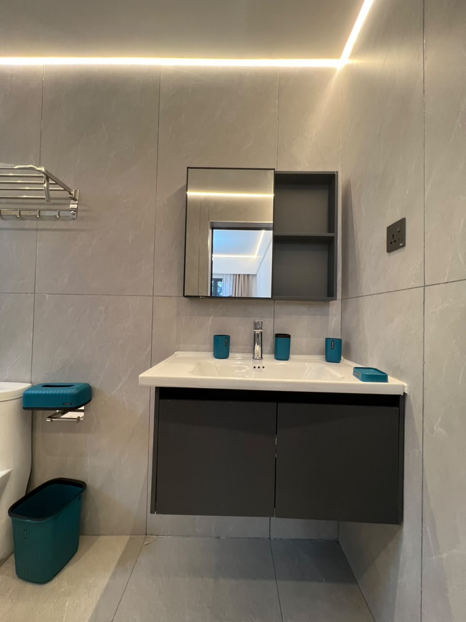 Longines Bay bathroom vanity with white washbasin, mirrored storage cabinet, grey wall tiles and modern fittings.