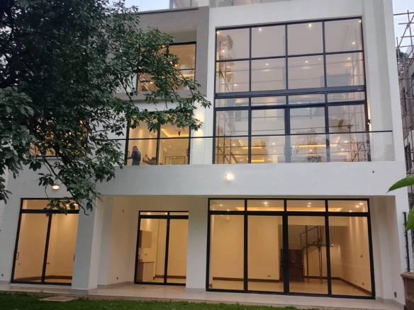 Radiant Villas luxury 6 bedroom villa exterior in Westlands Nairobi featuring large glass windows, balconies and private garden.