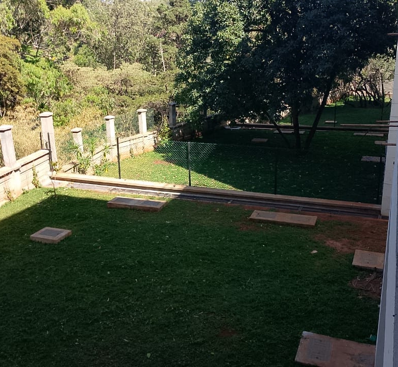 Radiant Villas private landscaped garden in Westlands Nairobi featuring green lawn, mature trees and perimeter fencing.